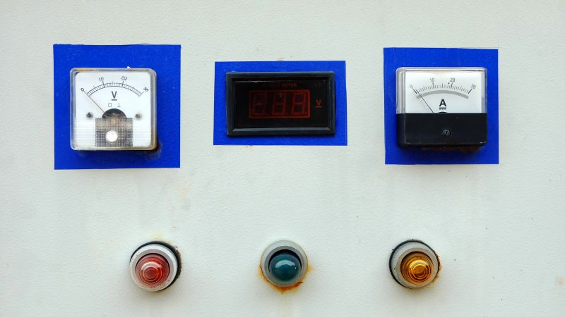 Control panel with analog voltmeter, digital voltage meter, ammeter, and red, green, yellow indicator lights below.