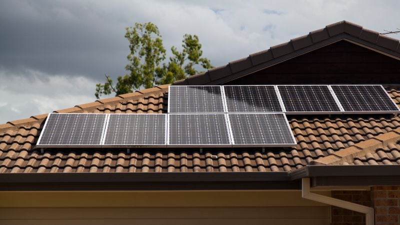 High-efficiency solar roof panels on residential home with rooftop tiles, promoting clean energy and sustainable living solutions for eco-friendly homeowners.